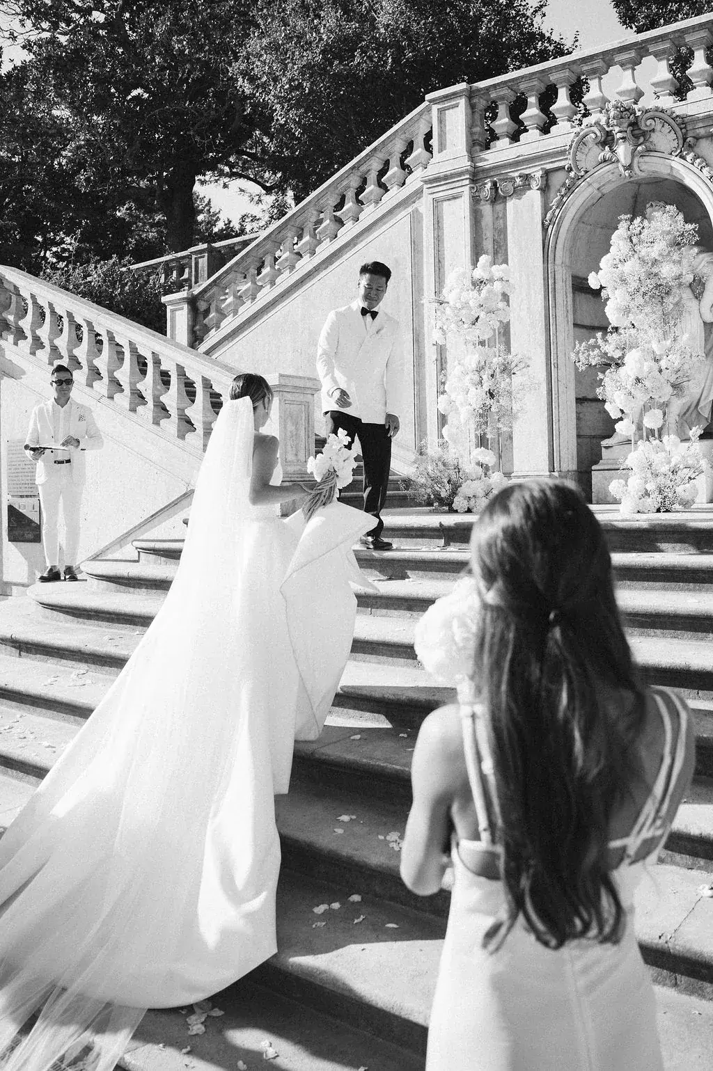 Couple portrait at a balcony under a vintage lantern, groom in black tie