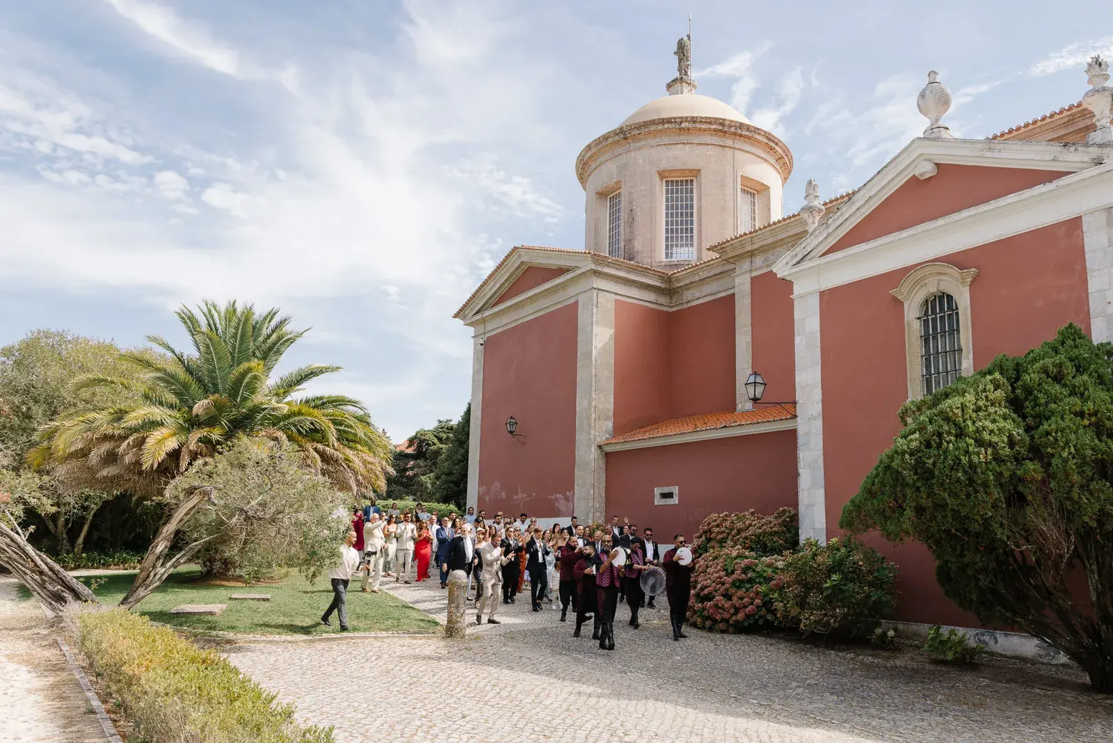Wedding procession past a red domed palace in Portugal