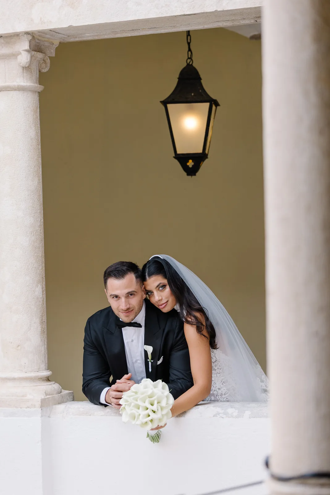 Black and white couple walking down ceremony aisle with petals under old tree