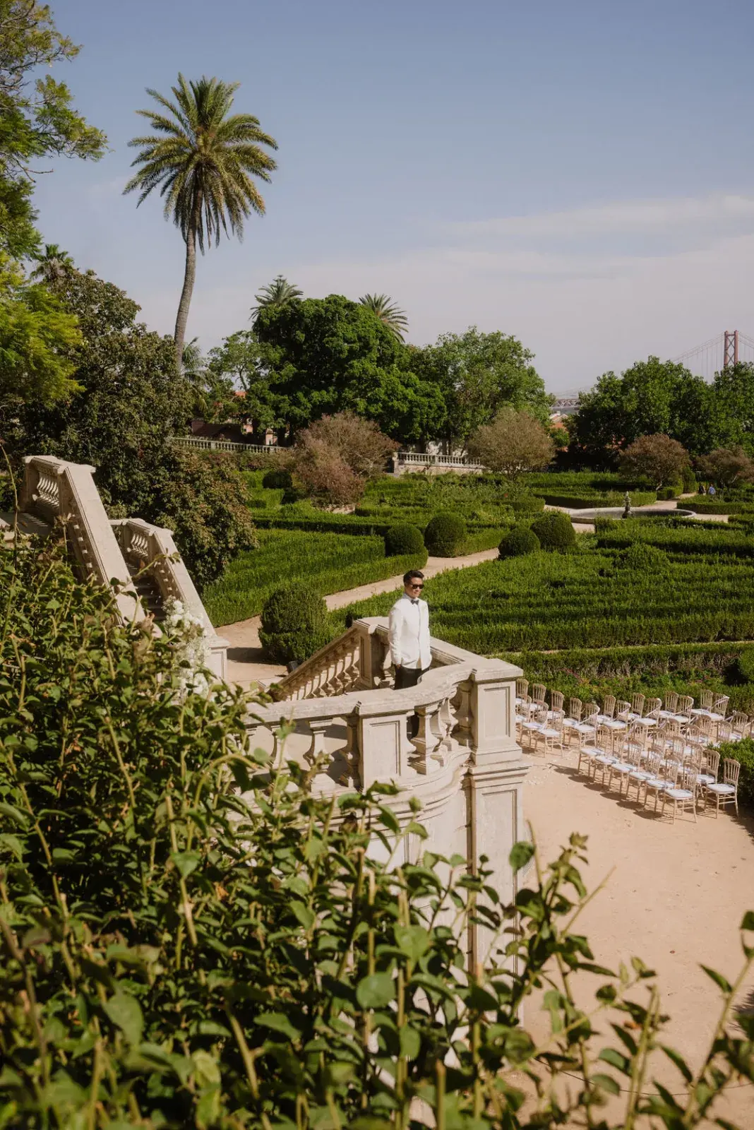 Palace botanical garden in Lisbon set for a ceremony, the 25 de Abril bridge on the horizon