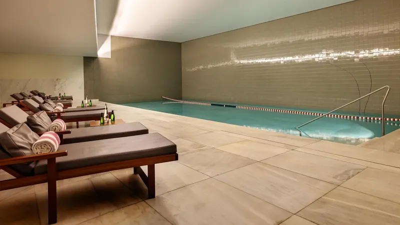 A piscina interior aquecida de mármore branco no spa de Álvaro Siza Vieira, Vidago Palace, Norte de Portugal