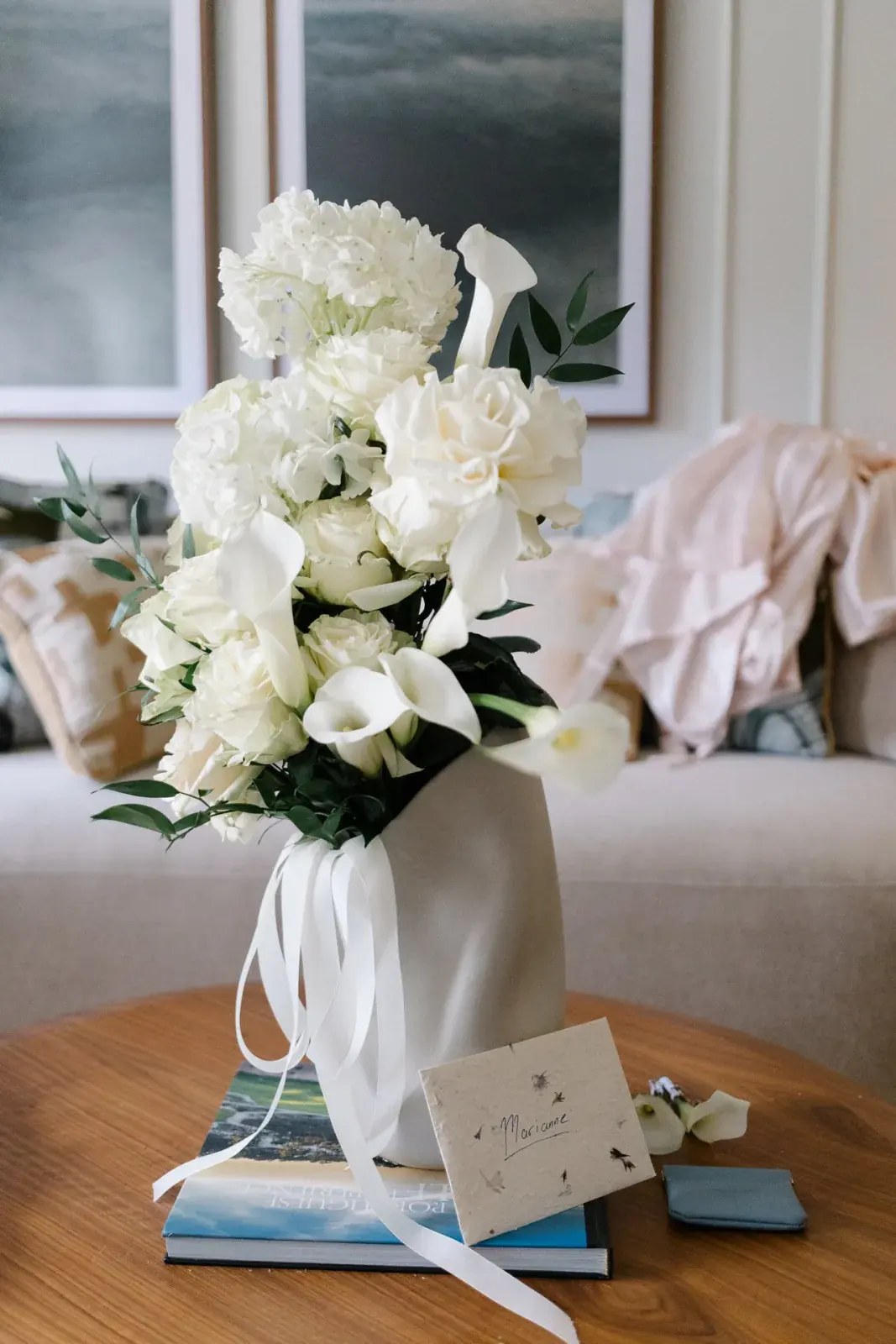 White bouquet of roses and calla lilies in the bridal suite beside a handwritten envelope