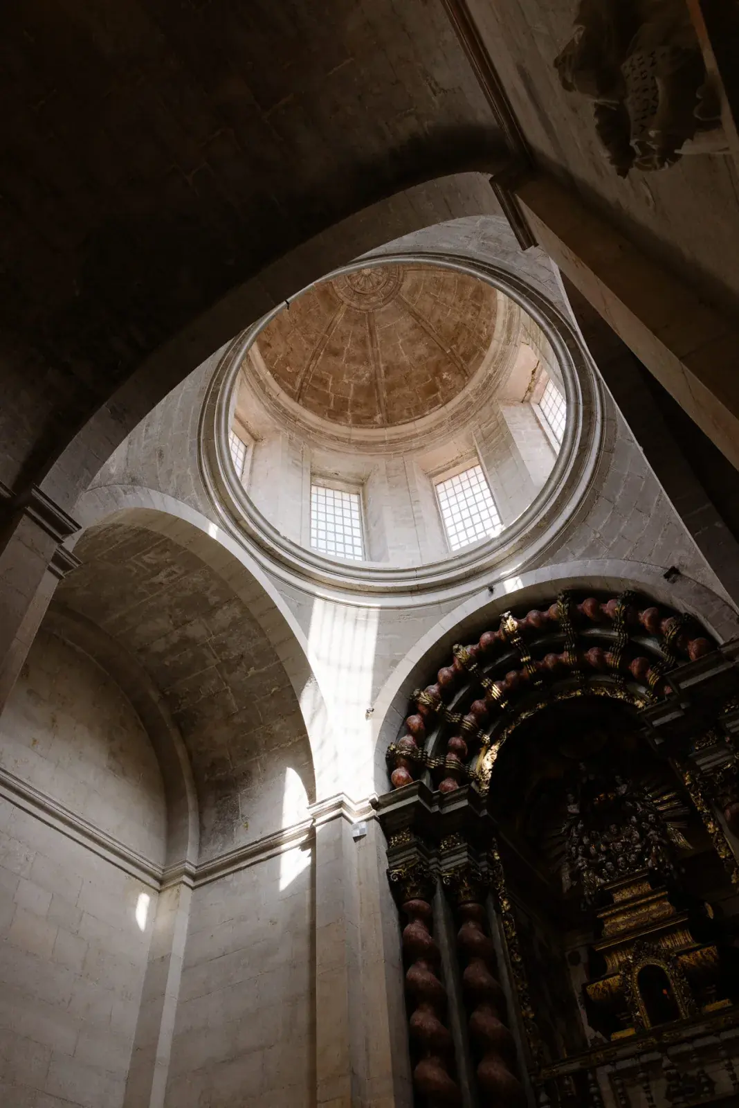 Stone dome and gilded altar caught in a single shaft of afternoon light before the ceremony